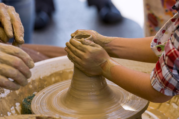 Close-up of a potter's wheel, teaching a child to make a clay object