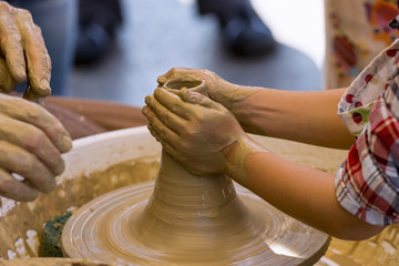 Close-up of a potter's wheel, teaching a child to make a clay object