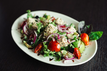 Salad with greens,cheese and onions on a white dish