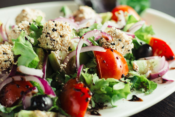 Salad with greens,cheese and onions on a white dish