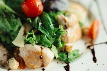 Caesar salad with chicken on white dish