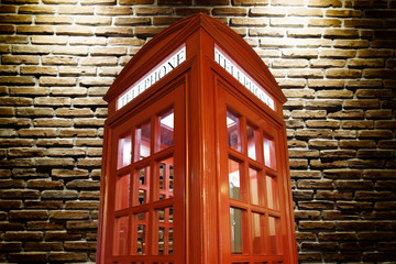 Obraz premium Telephone box and brick wall
