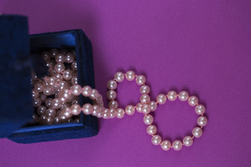 Pink beads on a purple background.