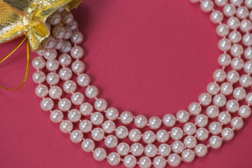 Pink beads on a red background.