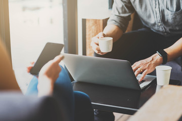 Man and woman using laptop and smartphone together in coffee sho