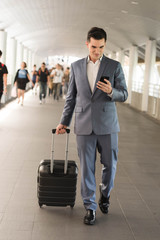 Business man talking via smart phone on the walk way with people