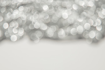 Blurred silver background with bokeh and sparkles.