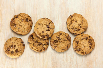 Pile of chocolate chips cookies on wooden board with copyspace