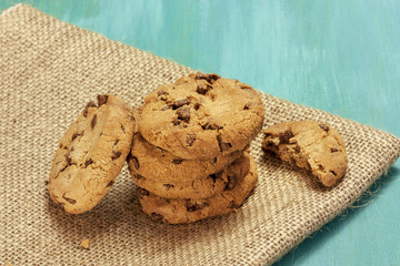 Chocolate chips cookies on burlap and teal blue textures