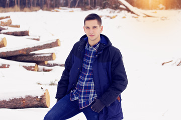 Handsome, stylish and young man in jacket standing in the forest. Early spring, sunny day. Men's...