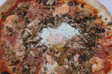 Pizza with egg, ham. In square with fountain.