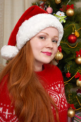 Beautiful girl in christmas decoration. Home interior with decorated fir tree and gifts. New year eve and winter holiday concept.