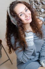 Pretty young girl in earmuff and pattern mittens. Winter.New Year.Studio.