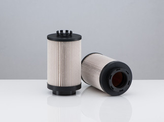 two automotive filter cylindrical shape  on a white background with reflection