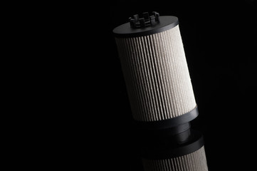 automotive filter cylindrical shape on a black background with reflection
