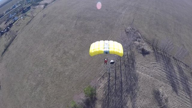 man riding his parachute after jumping from antenna