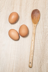 Fototapeta na wymiar Eggs with wooden spoon on wood table