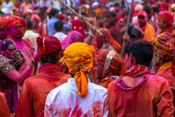 Very colorful celebration of Holi festival in India by beating men with Bamboo sticks - obrazy, fototapety, plakaty