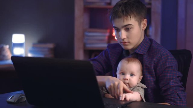Boy and baby playing with laptop