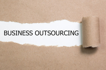 business outsourcing Message written under torn paper.