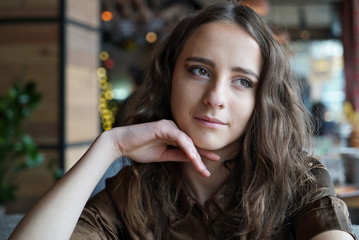 Obraz premium Shoulder portrait of long-haired girl in brown blouse. 