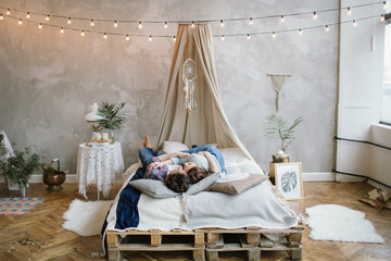 Young hipster couple having fun on handmade bed with dreamcatche