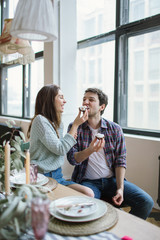 Young hipster couple feeding each other in rustic old loft