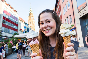 Girl is holding a big ice cream in front her face
