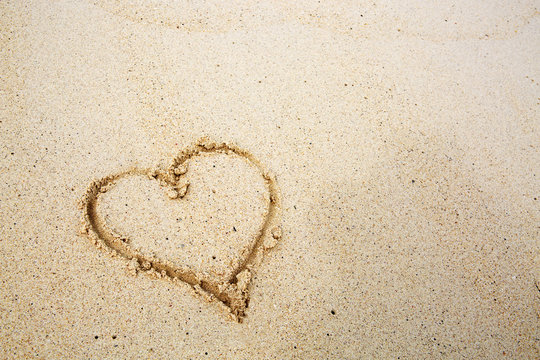 Hearts drawn on the sand of a beach.