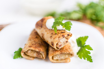 Pancakes filled with meat stuffing on a white plate