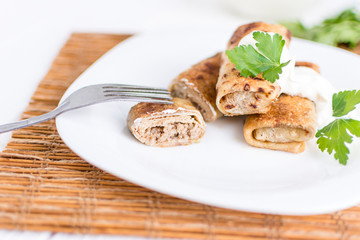Pancakes filled with meat stuffing on a white plate