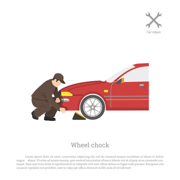 The mechanic sets chock for wheel. Car repair and maintenance