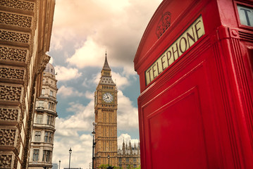 Fototapeta na wymiar London - Big Ben tower and a red phone booth. Vintage film filte