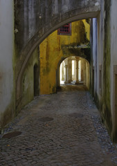 Fototapeta na wymiar Old street with arches and a stone blocks in Sintra, Portugal.
