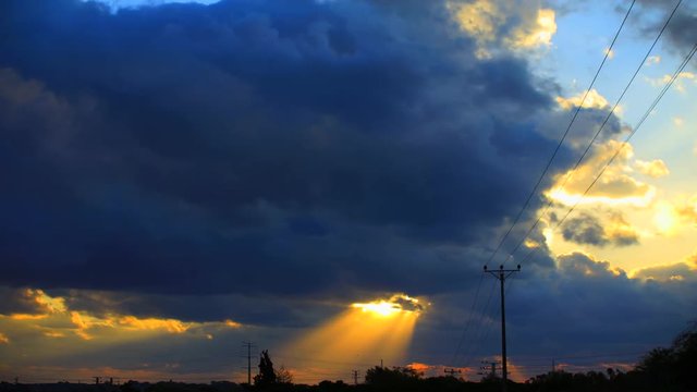 Time lapse video Sunset   through clouds  with sunbeam