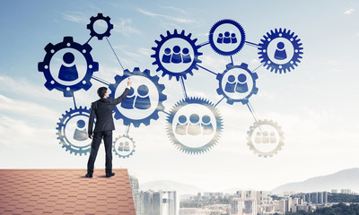 Businessman on house roof presenting teamwork and connection con