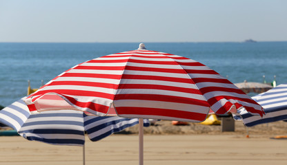 colored striped umbrellas on the sunny beach