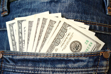 Cash, money is in the pocket of blue jeans