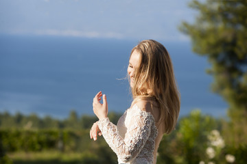 Portrait of beautiful Bride walking along sea coast wearing beautiful white wedding dress