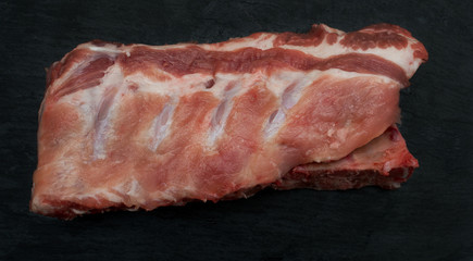 Raw Ribs eye steak on Black  board shot from above