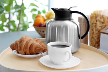 Breakfast with croissants and coffee on wooden table