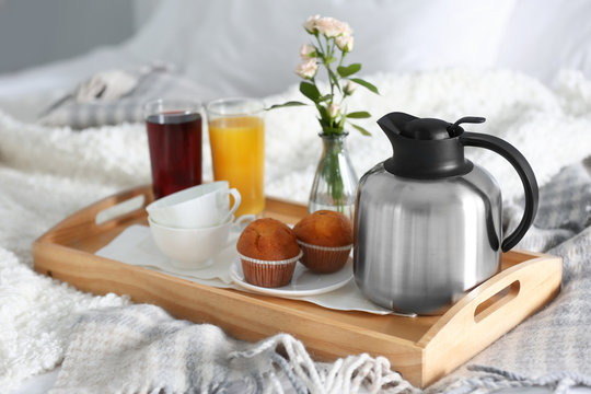 Breakfast in bed. Tray with juice, muffins and coffee