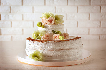 Obraz na płótnie Canvas Delicious wedding cake on white table and brick wall background