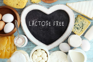 Allergic food concept. Dairy products and heart shaped board with text LACTOSE FREE on table