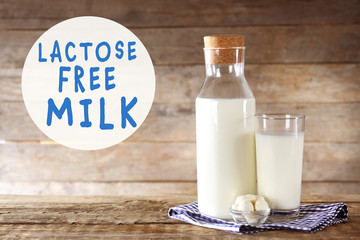 Allergic food products concept. Glass and bottle of milk on wooden background