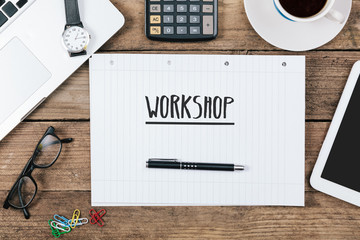 Workshop text on note pad, Office desk with computer technology,
