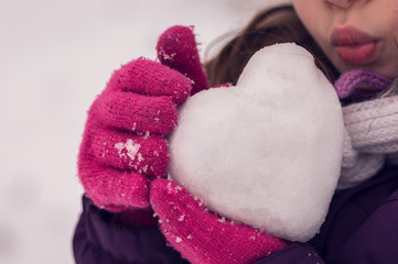 Girl kisses the icy heart. Valentine's day.