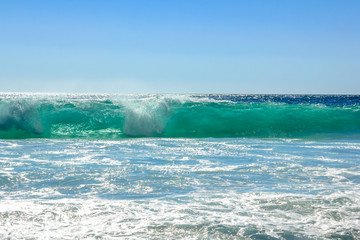 Big waves in a sunny day with blue sky. Extreme sports leisure concept. Powerful waves background with copy space. Summer vacation concept.