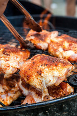 Seasoned grilled chicken cooking on barbecue in summer