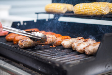 Corn and sausage on a summer gas grill barbecue being cooked